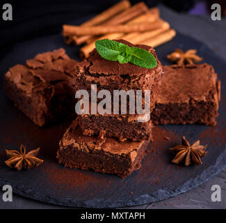 Quadratische Stücke von gebackenen Schokoladenkuchen auf schwarzem Graphit Platte, Ansicht der Brownie von oben Stockfoto