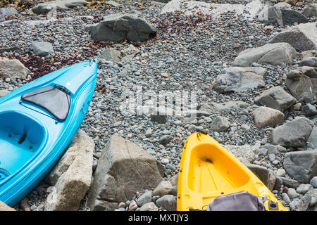 Zwei Kajaks gebunden, die auf der felsigen Strand. Stockfoto