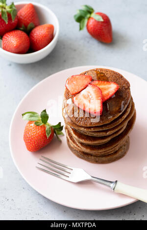 Glutenfreie Pfannkuchen mit Buchweizen und Hafer serviert mit Erdbeeren und Honig. Ansicht von oben, selektiver Fokus Stockfoto