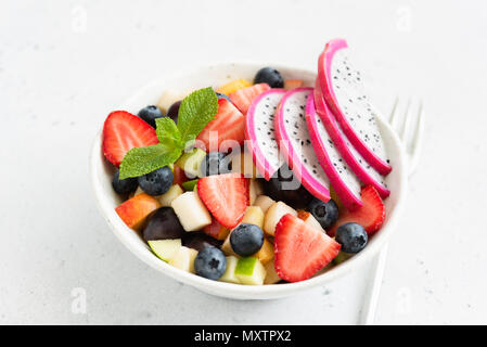 Thai Obstsalat mit pitaya und Mango in einer weißen Schüssel, Detailansicht. Konzept der Sommer, Urlaub, vegetarische und vegane Ernährung, gesunde Ernährung und Gesundheit Stockfoto