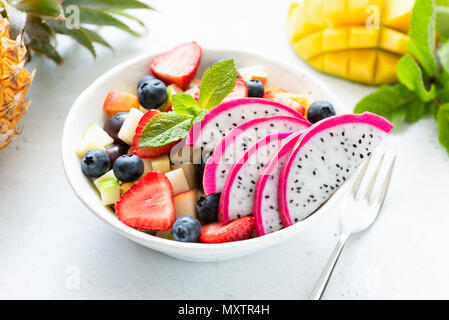 Thai Obstsalat mit pitaya und Mango in einer weißen Schüssel, Detailansicht. Konzept der Sommer, Urlaub, vegetarische und vegane Ernährung, gesunde Ernährung und Gesundheit Stockfoto