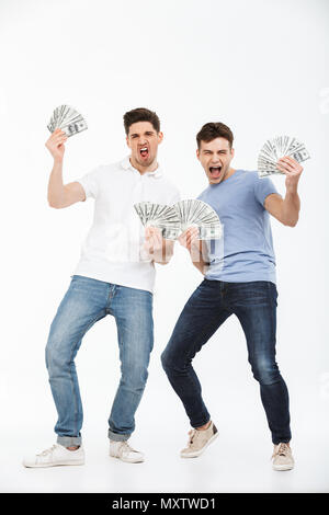 In voller Länge Porträt von zwei glückliche junge Männer mit Geld Banknoten und Erfolge feiern auf weißem Hintergrund Stockfoto