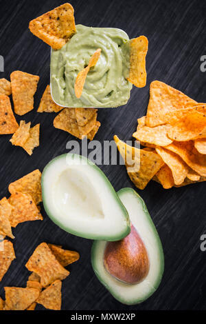 Avocado und guacamole Dip mit Tortilla Chips auf einem dunklen Hintergrund Stockfoto