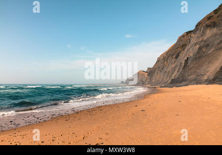 Eine einsame Strand mit vulkanischen Felsen und die blau-grüne Wasser des Atlantischen Ozeans in Sagres, Algarves, Portugal im Sommer. Stockfoto