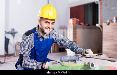 Sorgfältige schweren männlichen Arbeitnehmer ist die Vorbereitung für die Reparatur im Zimmer am Objekt Stockfoto