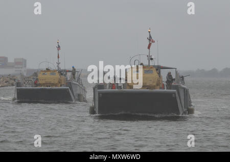 Us-Armee Soldaten zum 3. Bataillon zugeordnet, 27 Field Artillery Regiment und 188 Brigade Support Bataillons führen gemeinsame - Logistik-über-die-shore (JLOTS) Training mit Armee Seemänner des 7. Transport Brigade aus der Chesapeake Bay an craney Island, Virginia während des Betriebs Neptun Fury, Dez. 6, 2016. Ein High Mobility Artillery Rocket System (HIMARS element) reiste auf Landing Craft mechanisierten (LCM) zum Ufer dann ausgeführt simulierten HIMARS feuern Missionen. (U.S. Armee Foto von Sgt. Benjamin Parsons/18 Field Artillery Brigade freigegeben) Stockfoto