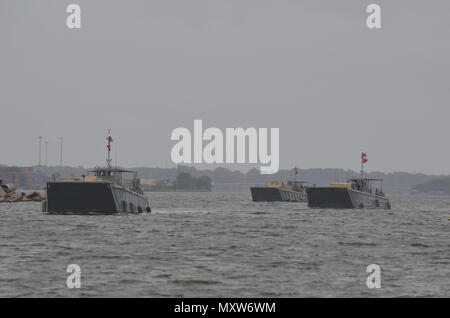 Us-Armee Soldaten zum 3. Bataillon zugeordnet, 27 Field Artillery Regiment und 188 Brigade Support Bataillons führen gemeinsame - Logistik-über-die-shore (JLOTS) Operationen mit Armee Seemänner des 7. Transport Brigade aus der Chesapeake Bay an craney Island, Virginia während des Betriebs Neptun Fury, Dez. 6, 2016. Ein High Mobility Artillery Rocket System (HIMARS element) reiste auf Landing Craft mechanisierten (LCM) zum Ufer dann ausgeführt simulierten HIMARS feuern Missionen. (U.S. Armee Foto von Sgt. Benjamin Parsons/18 Field Artillery Brigade freigegeben) Stockfoto