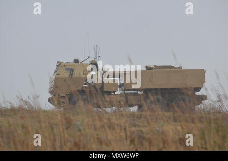 Us-Armee Soldaten zum 3. Bataillon zugeordnet, 27 Field Artillery Regiment und 188 Brigade Support Bataillons führen gemeinsame - Logistik-über-die-shore (JLOTS) Operationen mit Armee Seemänner des 7. Transport Brigade aus der Chesapeake Bay an craney Island, Virginia während des Betriebs Neptun Fury, Dez. 6, 2016. Ein High Mobility Artillery Rocket System (HIMARS element) reiste auf Landing Craft mechanisierten (LCM) zum Ufer dann ausgeführt simulierten HIMARS feuern Missionen. (U.S. Armee Foto von Sgt. Benjamin Parsons/18 Field Artillery Brigade freigegeben) Stockfoto