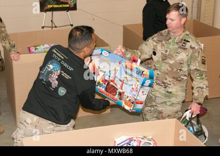 Sgt. 1. Klasse Joseph Cogburn, Chancengleichheit Advisor, 1st Brigade Combat Team, 82nd Airborne Division, spendet ein Spielzeug während der Operation Spielzeug Drop XIX Lotterie Tag am 9. Dezember in Fort Bragg, N.C. Cogburn ist ein Mena, Arche, native. (US Army Reserve Foto von Sgt. Darryl L. Montgomery, 319 Mobile Public Affairs Abteilung) Stockfoto