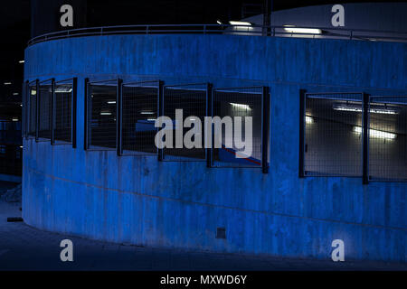 Düstere Parkgarage in blau dunkle Farben und fluoreszierendes Licht. Gruseliges Gefühl Stockfoto