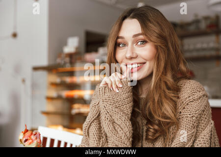 Portrait Nahaufnahme von niedlichen europäischen Frau lächelnd und Suchen auf der Kamera, beim Sitzen am Tisch im Café oder Restaurant Stockfoto