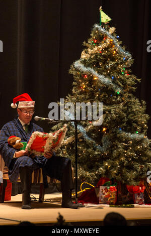 Jeffrey Carr, Matthew C. Perry High School stellvertretenden Schulleiter, erzählt wie das Symphonie Band "The Night Before Christmas" während der Betriebsferien Celebration Concert in der Sakura Assembly Hall in der Marine Corps Air Station Iwakuni, Japan, 7. Dezember 2016 spielt. Das Konzert präsentiert verschiedene Musikgruppen aus M.C. Perry und base Bewohner, Studenten und Mitarbeiter von Suo-Oshima städtische Grundschule, Waki Junior High School und Otake kommunale Ogata Junior High School zusammengebracht. Um das Konzert zu starten, spielte das Blasorchester "Angels We Have Heard auf High" für ca. 300 Gäste Stockfoto