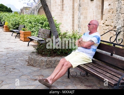 Mann mittleren Alters, der allein sitzt, keine anderen Leute in entspannter Stimmung, Stockfoto