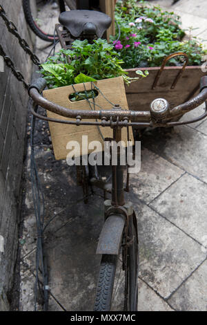 Ein antikes Fahrrad verwendet werden als Display Ornament an Obst und Gemüse am Borough Market in Central London. Floristen shop display Stück. Stockfoto