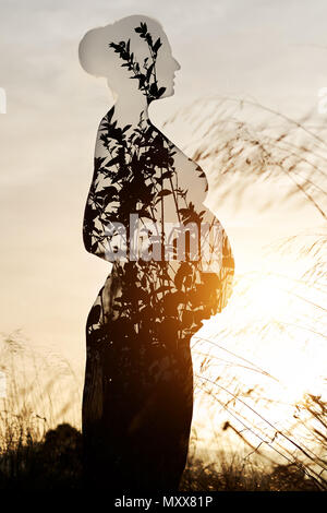 Double Exposure. Silhouette einer schwangeren Frau mit der Natur kombiniert Stockfoto