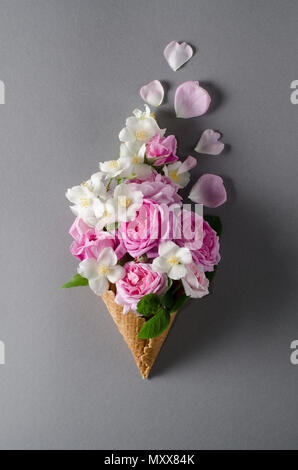 Frischer Frühling Rosen im Waffle Kegel. Schöne romantische Hintergrund in Flach Stil. Stockfoto