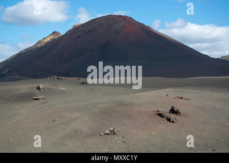 Blick auf schwarze Lava Berge bei geführten Wanderungen Discovery Tour Termesana Route im Nationalpark Timanfaya auf Lanzarote, Kanaren, Spanien. Stockfoto