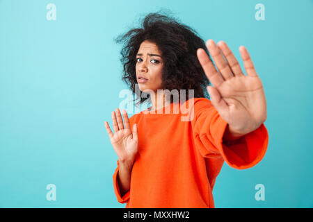 Bunte bild Nahaufnahme von bestimmt Frau Ausdruck Ratlosigkeit und Verwirrung mit stop Gesten und nein zu sagen über blau Hintergrund isoliert Stockfoto