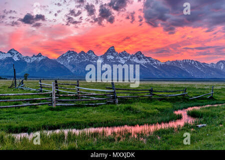 Sonnenuntergang am Grand Teton - Panoramablick auf einen spektakulären Sonnenuntergang am Teton Range, aus einem alten Ranch in Mormonischen Reihe, Grand Teton National Park, USA gesehen. Stockfoto