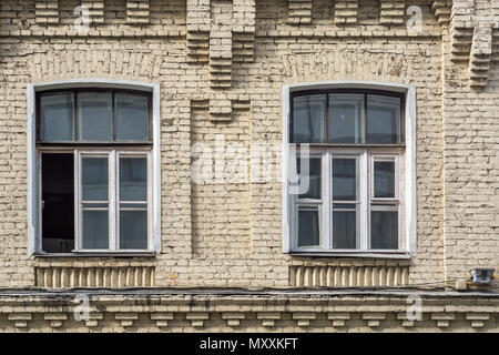 Zwei Fenster, das auf der Fassade des Gebäudes beige Ziegel entfernt. Stockfoto