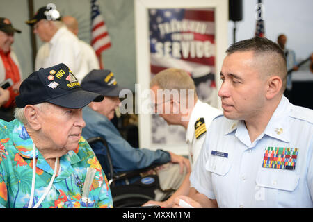 Petty Officer 1st Class Josh Lamborn, ein Yeoman bei Coast Guard Base Honolulu stationiert und heimisch in Santa Ana, Kalifornien, spricht mit ehemaligen Marine Corps Pfc. James Krodel, ein Weltkriegveteran und gebürtige Quitman, Texas, bevor eine amerikanische Fluggesellschaft Ehre Flug zurück nach Los Angeles am internationalen Flughafen von Honolulu, Dez. 9, 2016. Mehr als 100 Weltkriegveterane, einschließlich Pearl Harbor Überlebenden, in Erinnerung Ereignisse während der gesamten Woche nahmen den Mut und die Opfer derjenigen, die während der dez. 7, 1941 zu Ehren, und in der gesamten pazifischen Theater. Dez. 7, 2016, markierte den Stockfoto