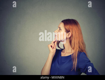 Profil von junge rothaarige Frau berühren Kinn und sah in Gedanken und Ideen Stockfoto