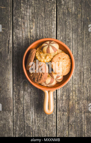 Verschiedene Arten von sweet Cookies in Schüssel auf alten Holztisch. Stockfoto