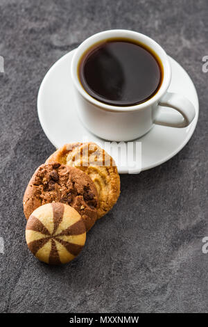Tasse Kaffee und süßes Cookies auf Schwarzen Tisch. Stockfoto