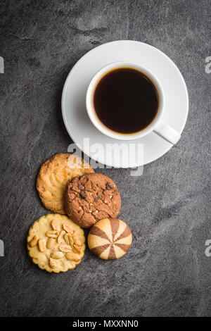 Tasse Kaffee und süßes Cookies auf Schwarzen Tisch. Stockfoto