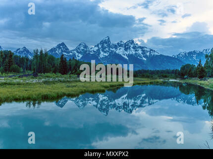 Dämmerung Teton Bergkette am Snake River - einem bewölkten Frühling Dämmerung Blick auf Teton Bergkette in ruhigen Snake River im Grand Teton National Park, Wyoming, USA widerspiegelt. Stockfoto