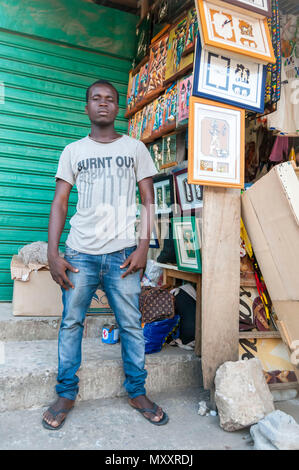 Junge afrikanische Mann street Hersteller Verkauf von Kunstwerken auf dem Markt. Abidjan, Elfenbeinküste, ca. Mai 2013. Stockfoto