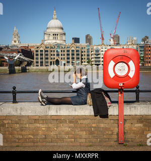 London, UK, September 2017. Frau sitzt auf der Themse Balustrade vor der St. Paul's Cathedral. Quadratischen Format. Stockfoto