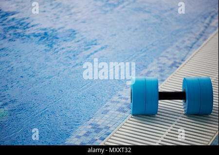 Die kettlebell für Wassergymnastik liegt am Rand des Pools. In der Nähe des Wasser. Übung, Schwimmen und einen gesunden Lebensstil. Stockfoto