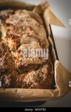 Nahaufnahme von einem hausgemachten Kuchen in einem Fach mit braunen Backpapier. Hochformat. Stockfoto