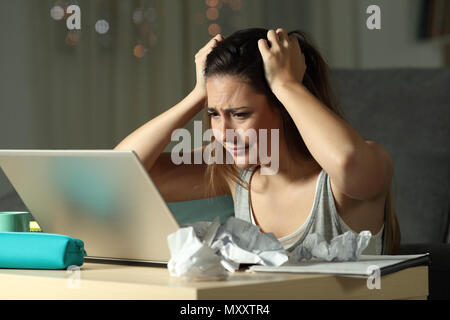 Frustrierte Kursteilnehmer entdecken einen Fehler online in einem Laptop in der Nacht zu Hause Stockfoto