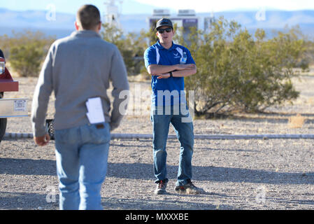 Casey Kleisinger, ein Mitglied des Teams von Robins Air Force Base, Ga, Signale einer Mitmannschaftskamerad während ein Szenario als Teil der 2016 Air Force Research Laboratory Kommandeure Herausforderung am Nevada National Security Website, Las Vegas, NV., Dez. 13, 2016. Mannschaften wurden sechs Monaten eine komplette Zähler - Unmanned Aerial Systems in Base Defense zu Hilfe zu entwickeln. Robins' system ist eine vielschichtige integriertes System verwendet ein Radar und Kamera System für den Nachweis und die Identifizierung. Es verwendet auch ein Hunter killer Drohnen für die Überwachung des Fernmeldeverkehrs und Wasserwerfer für Aufnahmen aus dem Himmel. (U.S. Luft für Stockfoto