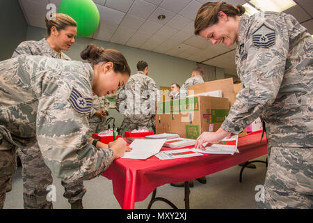 Tech. Sgt. Jane Hunter, Links, 177Th Communications Flug und Master Sgt. Jamie Nieves, rechts, Bauingenieur 177th Squadron, sowohl mit den New Jersey Air National Guard, Karten für die Bewohner bei der New Jersey Veterans Memorial Home in Vineland, N. J., Dez. 13, 2016. Mehr als 80 Viertklässler aus der Seaview Volksschule in Linwood, N. J., verband die 18 Flieger urlaub Lieder zu singen und ausgeteilten Karten zu den Bewohnern des Haus während des 16. jährlichen Urlaub ongfest" auf der Startseite. (U.S. Air National Guard Foto von Master Sgt. Mark C. Olsen/Freigegeben) Stockfoto