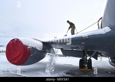 Airman Jesus Hilario, 92 Aircraft Maintenance Squadron Crew Chief, Manuell deices einer KC-135 Stratotanker von schneeschaufeln aus der Tragfläche Dez. 12, 2016, bei Fairchild Air Force Base, Washington. Während der Wintermonate, Flieger im Schnee sitzen auf und rund um das Flugzeug mit Schaufeln und Seile entfernen. (U.S. Air Force Foto/Senior Airman Mackenzie Richardson) Stockfoto