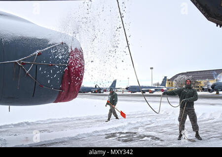 Senior Airman Benjamin Bennett, 92 Aircraft Maintenance Squadron Crew Chief, Manuell deices einer KC-135 Stratotanker mit einem Seil Dez. 12, 2016, bei Fairchild Air Force Base, Washington. Durch die Bewegung eines Seiles über harte Bereiche des Jet, einschließlich Rumpf und Tragflächen zu erreichen, Flieger, kann erfolgreich das schwere Blatt Schnee entfernen, bevor die Anwendung Enteisungsflüssigkeit. (U.S. Air Force Foto/Senior Airman Mackenzie Richardson) Stockfoto