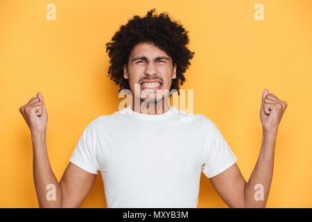 Portrait eines wütenden jungen afrikanischen Kerl über Gelb Hintergrund schreien Stockfoto