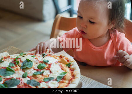 Baby Mädchen essen Pizza im italienischen Restaurant, gesund, ungesundes Essen, Kinder fast food Stockfoto