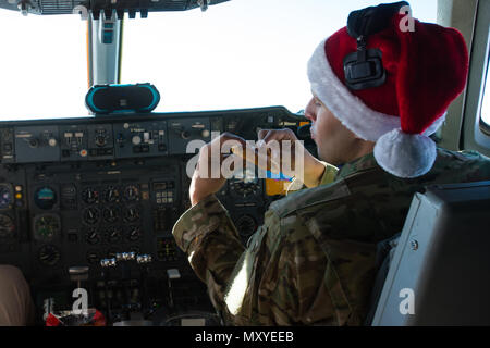 Ein 380th Air Expeditionary Wing KC-10 Extender Pilot aß aufgewärmte Pizza während eines Aufrufs, der am 25. Dezember 2016 die inhärente Entschlossenheit der Combined Joint Task Force über den Irak unterstützte. Der KC-10 Extender mit drei General Electric CF6-50C2 Turbofan-Triebwerken betankt Flugzeuge der Koalition und ermöglichte ausgedehnte Lufteinsätze. Die Besatzung benutzte kleine Öfen, um Feiertagsessen zuzubereiten, während sie Luftbetankungen durchführte und Koalitionsoperationen gegen ISIL im Irak und Syrien unterstützte. Stockfoto