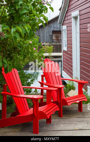 Zwei hölzerne Gartenmöbel auf einem Laufbelag Deck in Steveston, British Columbia, Kanada Stockfoto