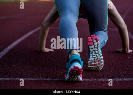 Sport schöne Mädchen auf dem Laufband bereit, ein großes Stadion zu laufen, Nahaufnahme Stockfoto