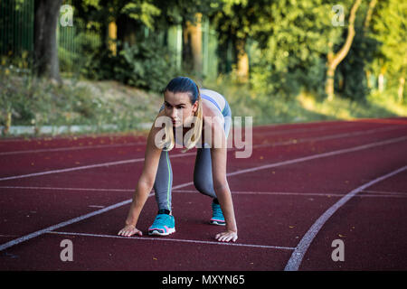 Sport schöne Mädchen auf dem Laufband bereit, ein großes Stadion zu laufen, Nahaufnahme Stockfoto