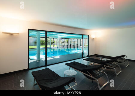 Hallenbad, ein modernes Haus mit Whirlpool, Zimmer mit Sonnenliegen Stockfoto