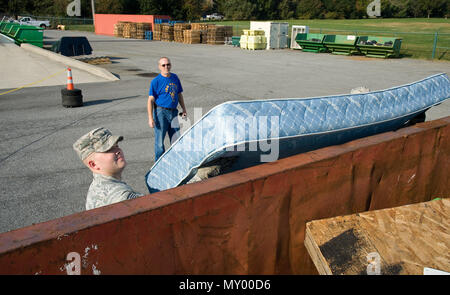 Deral Freysinger, Bauingenieur 436th Squadron qualifizierte Recycling Program Manager, Uhren Staff Sgt. Jonathan Judy, 436Th CES Flieger Schlafsaal Führer, eine Matratze in einem 30-cubic Yard roll-off-container Nov. 3, 2016, an das Recycling Center auf Dover Air Force Base, Del Freysinger gewährleistet alle an das Recycling Center gebracht Elemente in der richtigen Container platziert wurde. (U.S. Air Force Foto von Roland Balik) Stockfoto