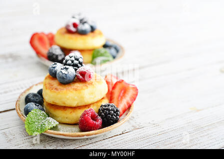 Quark Pfannkuchen, syrniki, Quark Krapfen mit frischen Beeren closeup Stockfoto