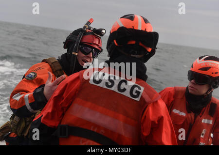 HAMPTON BAYS, NY-Flieger mit 101 Rescue Squadron und 103 Rescue Squadron Verhalten hoist Training mit United States Coastguardsmen von US Coast Guard Station Shinnecock zum 22. Dezember 2016. Während dieser Ausbildung, die Schutzengel aus der 103 RQS wurden über Hoist aus ein HH-60 Pavehawk auf das Deck des Schneidwerk abgesenkt. Danach wird das Flugzeug praktiziert Fallenlassen und Entfernen patient Würfe, vor dem Heben der Schutzengel sichern und für die Rückkehr zum Ausgangspunkt. (US Air National Guard/Staff Sergeant Christopher S. Muncy/freigegeben) Stockfoto