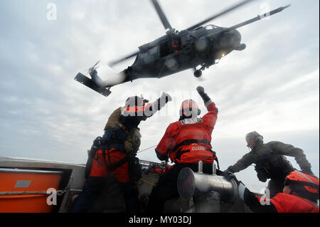 HAMPTON BAYS, NY-Flieger mit 101 Rescue Squadron und 103 Rescue Squadron Verhalten hoist Training mit United States Coastguardsmen von US Coast Guard Station Shinnecock zum 22. Dezember 2016. Während dieser Ausbildung, die Schutzengel aus der 103 RQS wurden über Hoist aus ein HH-60 Pavehawk auf das Deck des Schneidwerk abgesenkt. Danach wird das Flugzeug praktiziert Fallenlassen und Entfernen patient Würfe, vor dem Heben der Schutzengel sichern und für die Rückkehr zum Ausgangspunkt. (US Air National Guard/Staff Sergeant Christopher S. Muncy/freigegeben) Stockfoto